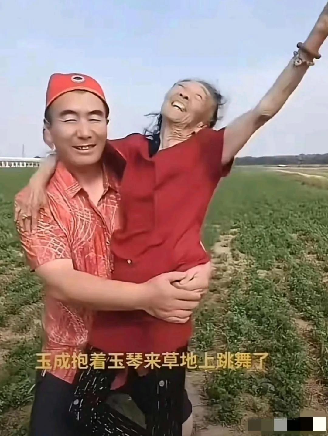 瞧，鲜衣盛装的玉成抱着玉琴来草地上跳舞啦：笑容灿烂的老妻耳环戒指手串全副武装，着