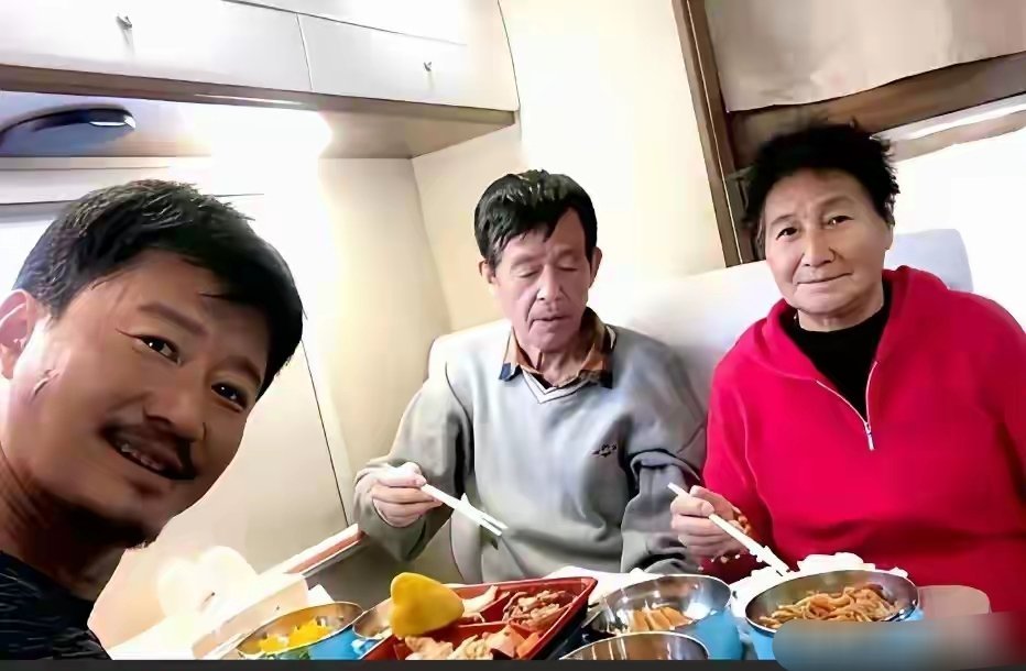 吴京与父母在高铁上就餐时的一幕，饭菜挺丰盛。 