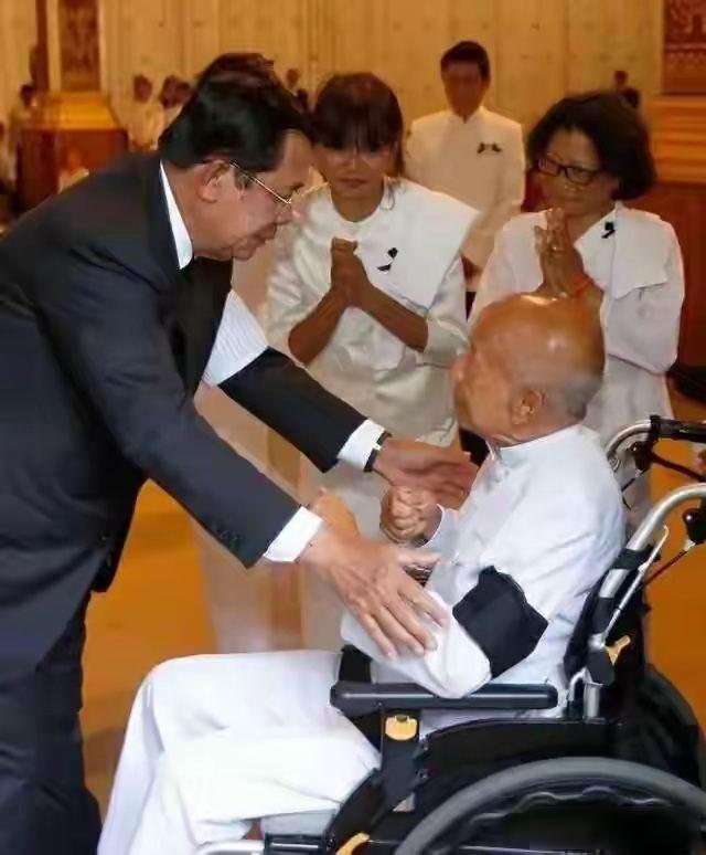 2025年12月15日，一张老照片又火了起来，洪森弯下腰去握住坐在轮椅上的拉那烈