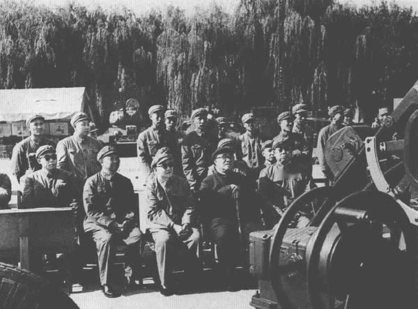 1965年10月24日，朱德委员长(前排左3)在后勤学院参观全军武器装备展览时听