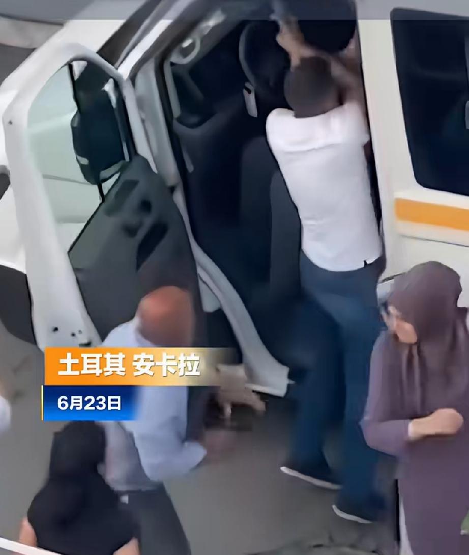6月23日，土耳其安卡拉。蓝衣男子挥舞手枪，在班车门口与司机争执，路人挡在他俩中