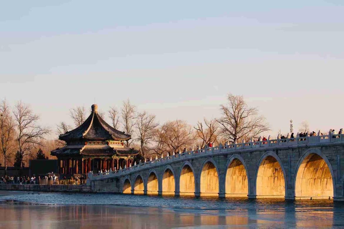 冬至前后，落日余晖便洒落颐和园昆明湖，缓缓照射进十七孔桥的拱洞，桥洞熠熠生辉 桥