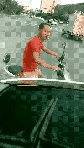 这个红衣男子是怎么回事啊？她怎么这么狂？她骑车横过马路，影响别人小车正常行驶还不