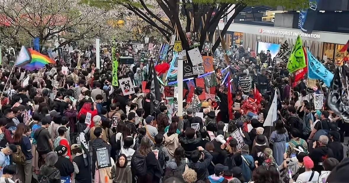 【】日本左翼群体在东京举行了反战集会，反对战争、反对高市早苗，现场有人举起了彩旗