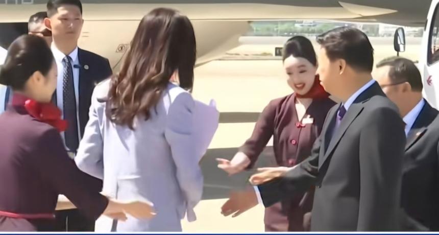 郑下机后抱着鲜花，要腾出手来，握手就迟了那么一下，她还是很礼貌。