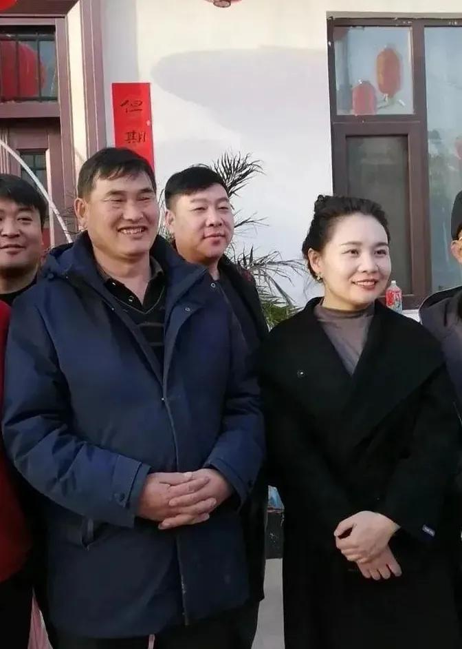 镜头中的朱之文衣着笔挺，发型利落，浓眉小眼，笑容灿烂，身旁的美女皓肤如玉，清雅端