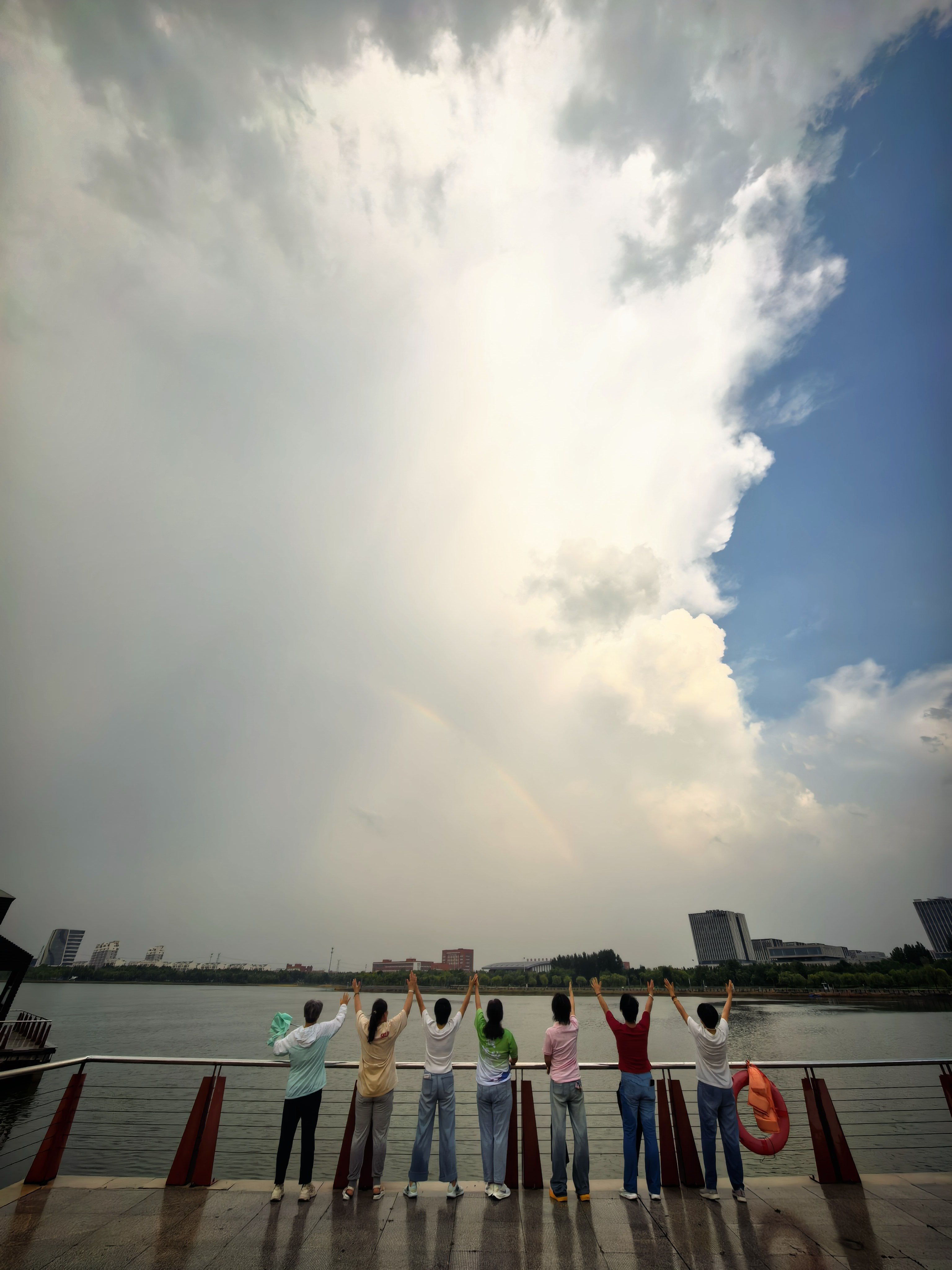 夏雨初歇，云开见虹。东营 悦来湖静水含光，落日穿云，长虹卧空。 东营·东营悦来湖