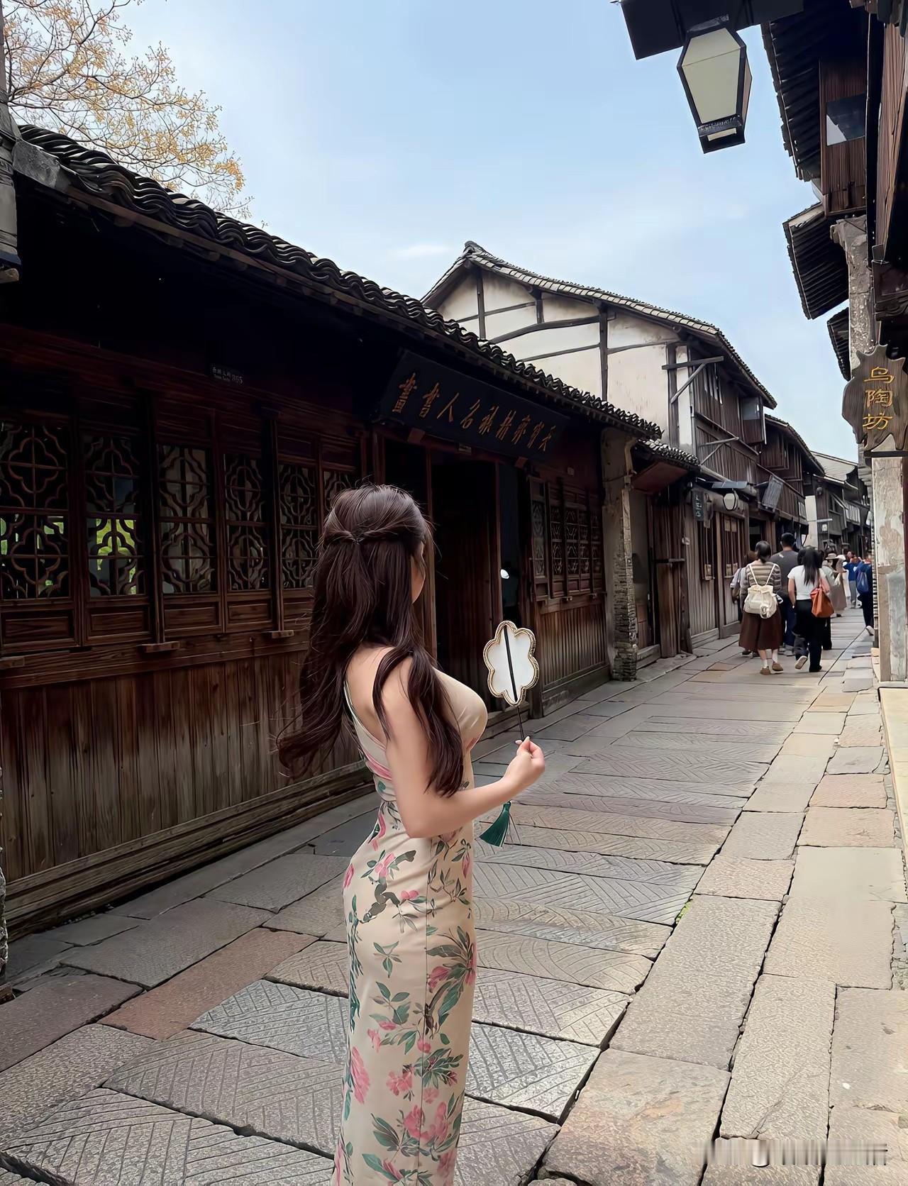 《她在古镇的晴日里》
 
青石板的纹路里，藏着春天的脚步
她的旗袍上，开着永不凋