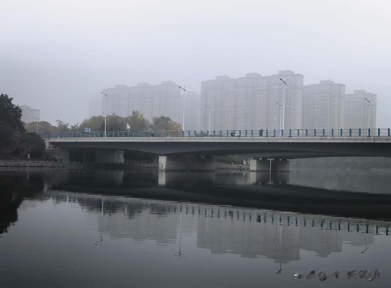 晨雾笼桥隐画檐，
平波映影水天黏。
孤禽立尽寒汀上，
静待朝阳破霭帘。