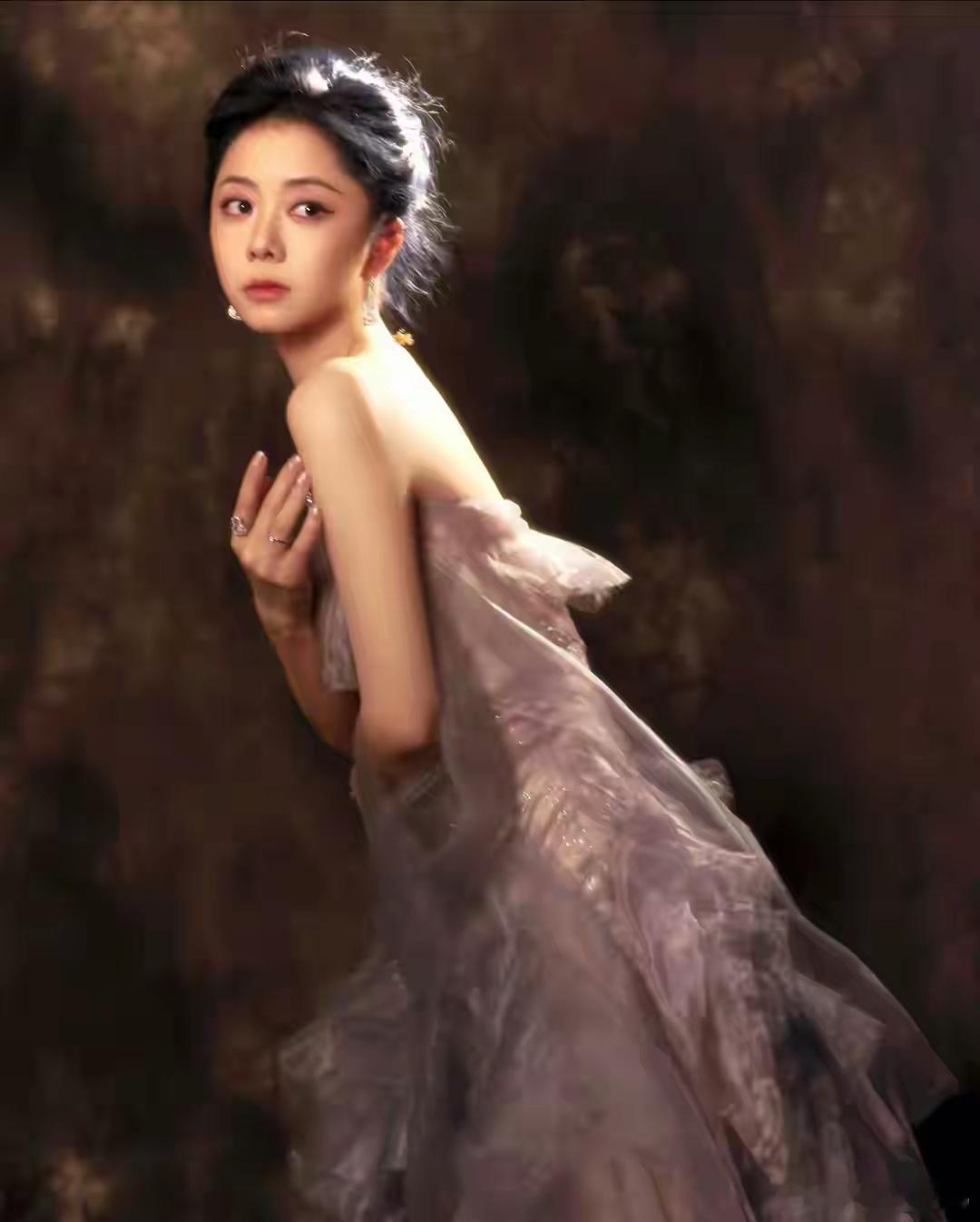 谭松韵一袭紫色纱裙加身，裙摆上的碎钻在光下流转，举手投足间恰似从古典油画中走出的
