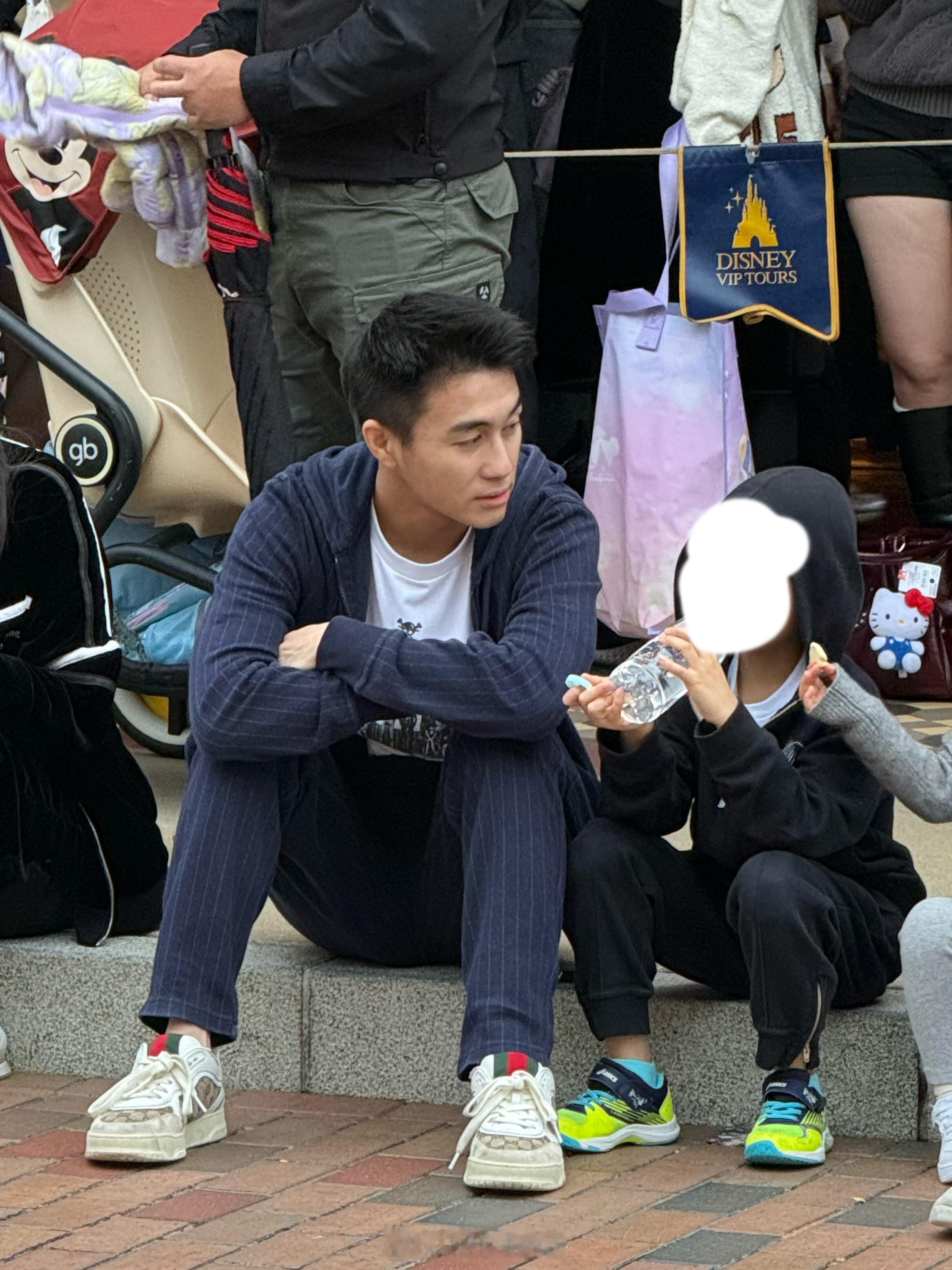 何猷君带儿女游玩迪士尼何猷君和儿女坐路边看花车巡游 何猷君带儿女游玩迪士尼，坐路