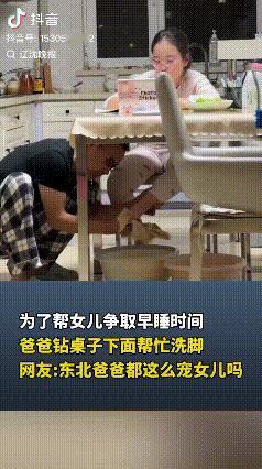 辽宁，一爸爸为了让上初中的女儿早点睡觉，女儿坐在桌子旁写作业，他钻到桌子底下给女