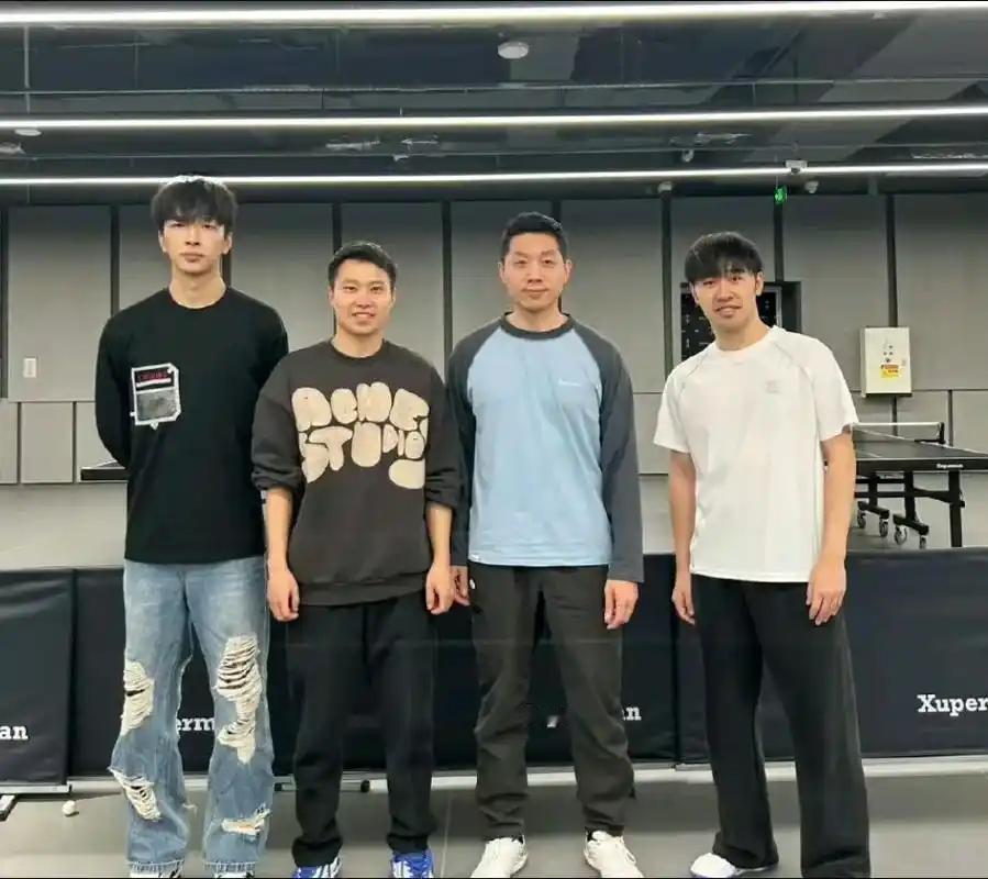 4人合影于''大蟒''许昕的球馆内：

我认出了穿着黑色长袖T恤、破洞牛仔裤的肖