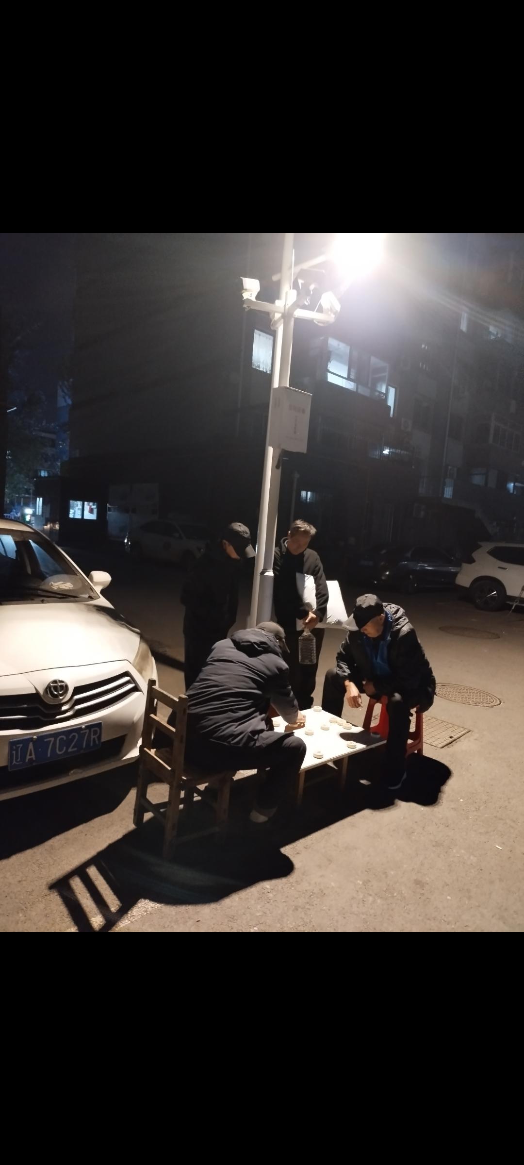 这是我昨天晚上拍下的照片。

两个老人在路灯下象棋对弈。

你们不知道，这两天沈