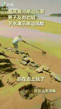 “上人民日报了。”山东济南，小男孩在黄河岸边拿着捕鱼网在泥沙边玩耍，一名男子厉声