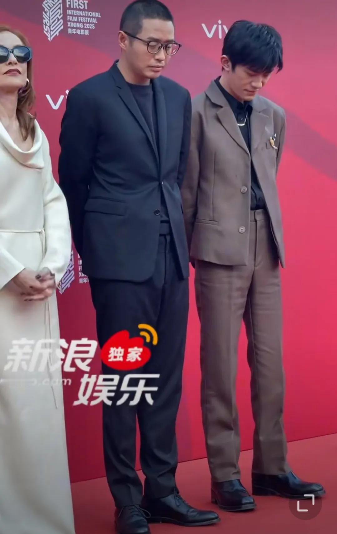 FIRST影展的红毯灯光正亮，当易烊千玺侧身和文牧野导演咬耳朵时，嘴角那抹没藏住