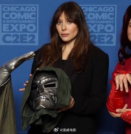 奥妹儿在最近漫展的粉丝合影环节中，拿着毁灭博士的“头”。