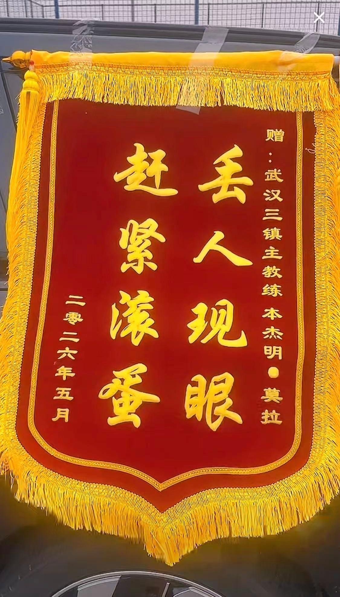 此时此刻的武汉三镇训练基地门外，武汉球迷在基地外面拉起了“莫拉，下课”的横幅……