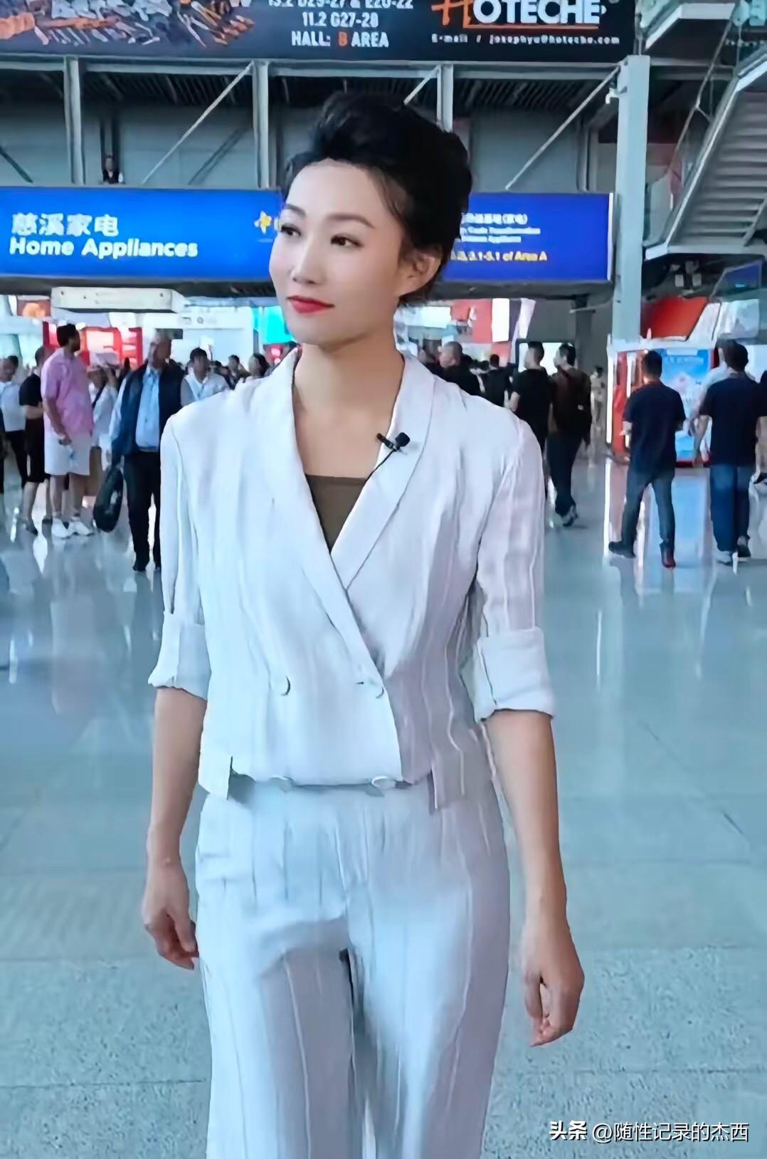 难得一见央视主持人李梓萌的一身休闲装打扮参加活动，49岁的她穿着浅灰的套装，盘着