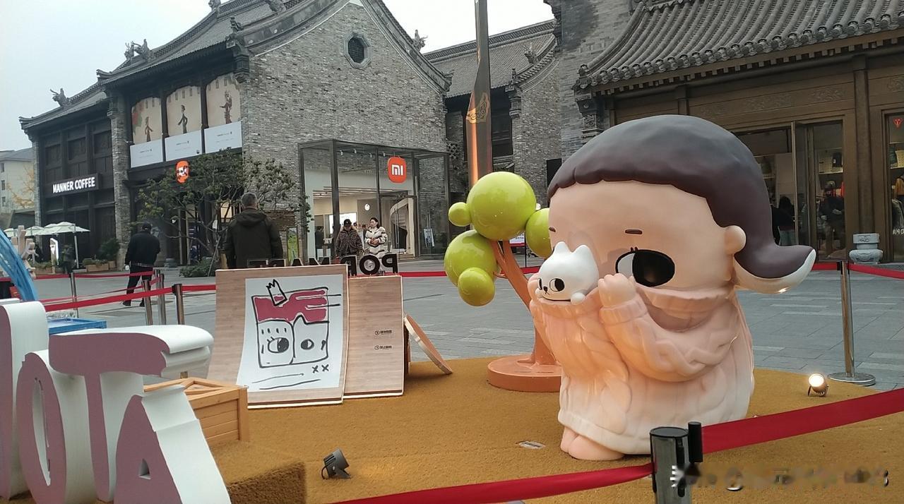 分享一张街景照片和孩子一起逛城墙遗址，古建筑物很有特色。商铺门口各种卡通引人注目