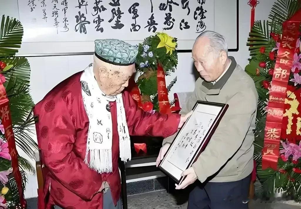 寿堂之中花团锦簇，红绸贺幅高高悬挂，这是张蕴钰将军九十寿辰时的珍贵留影。
身着红