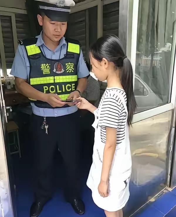 中午，南京街头的交警岗亭。一个小女孩背着书包走进来，递上一部手机。

交警陈磊收