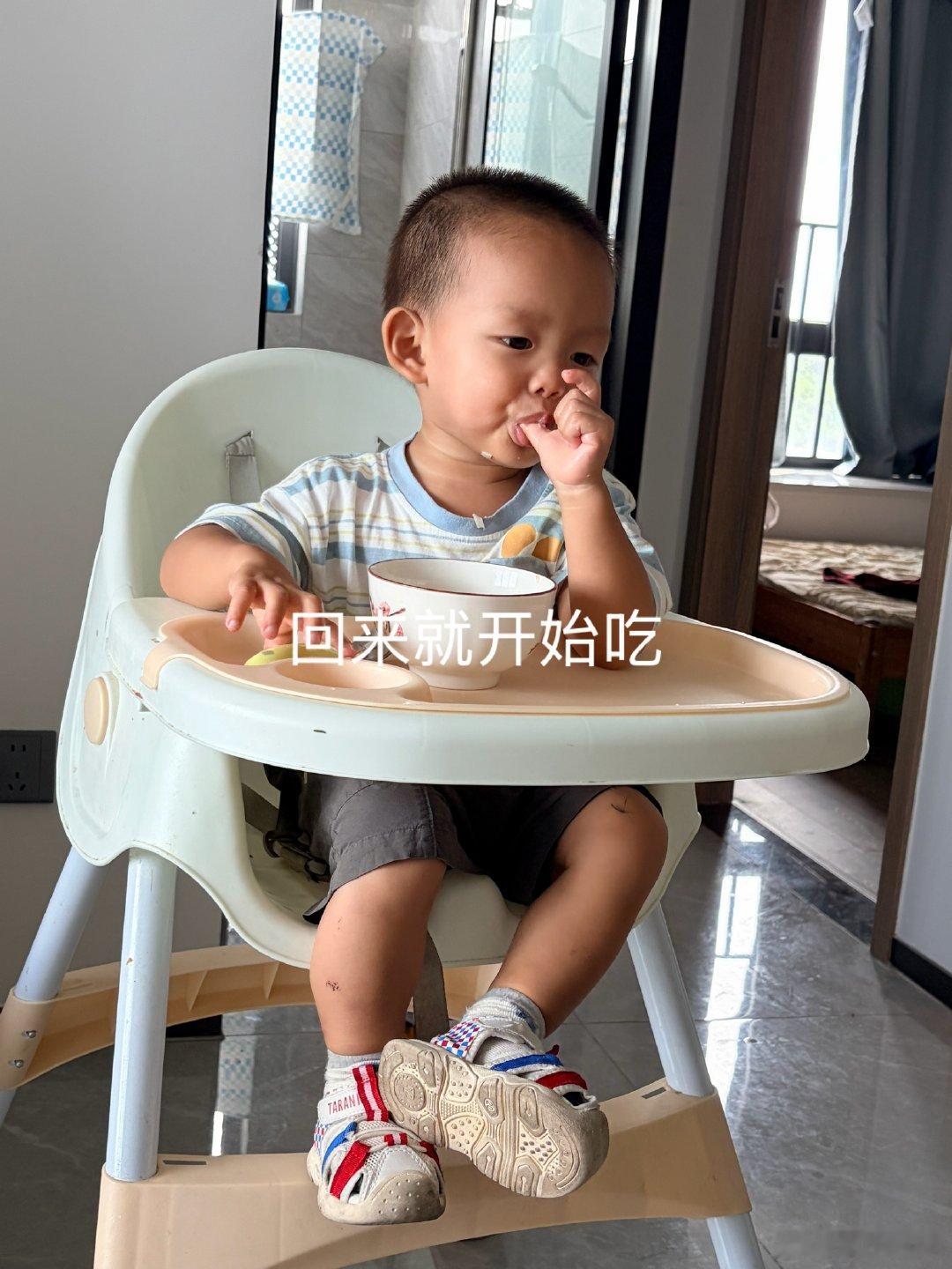 跟着外婆出去玩回来了，回来就去厨房找吃的！看到早上吃剩的面条就不放手了～抱在餐椅