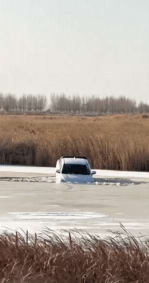 车掉冰窟窿里了，有钱人的快乐我们体会不到，可惜了一辆车。
下去之前也不看看冰层有