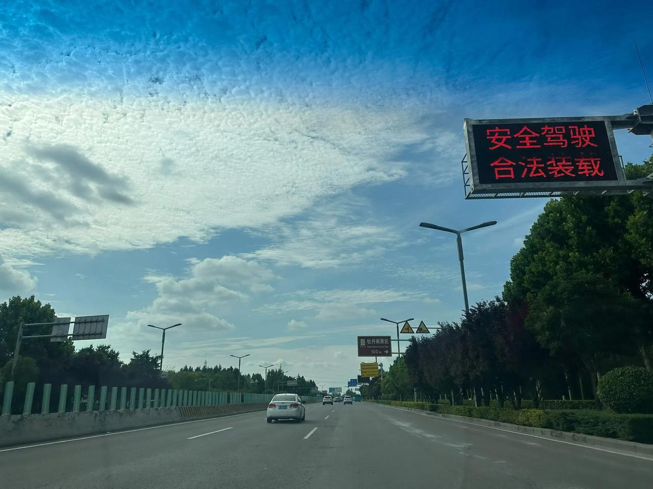 记录我的2026驱车行驶在开阔道路，漫天云朵舒展铺在晴空，抛开琐事随前路慢行，原