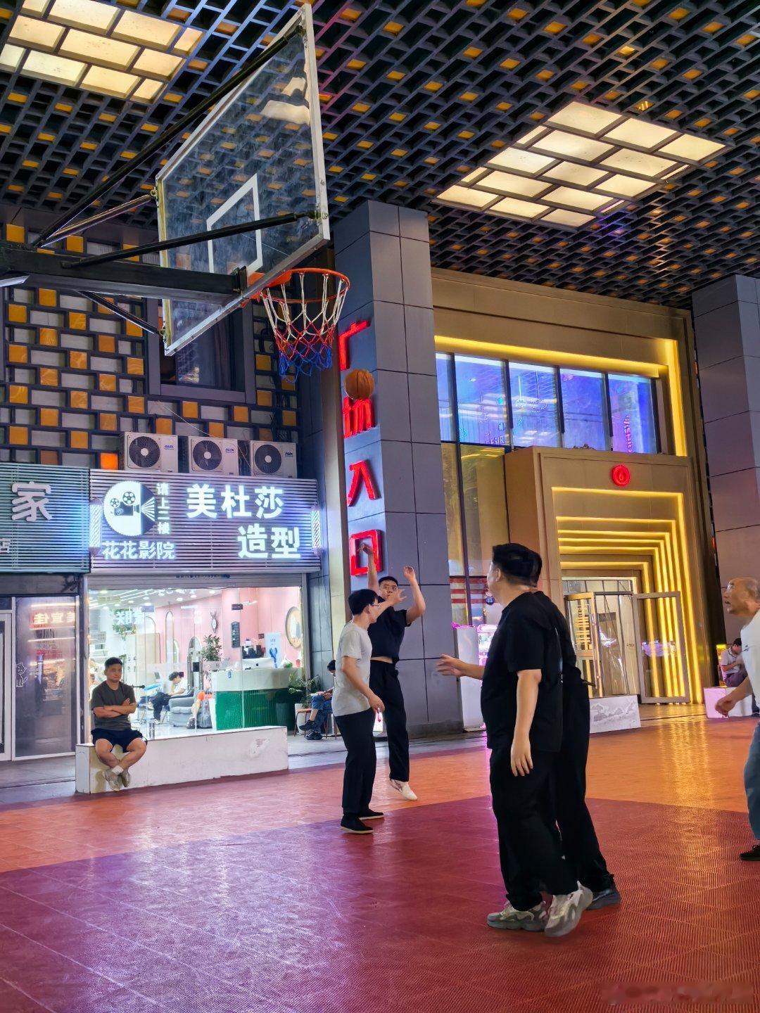 西安旧事 夜幕漫上解放路万达，格构吊顶灯火错落。广场中央的露天球场格外鲜活，篮球