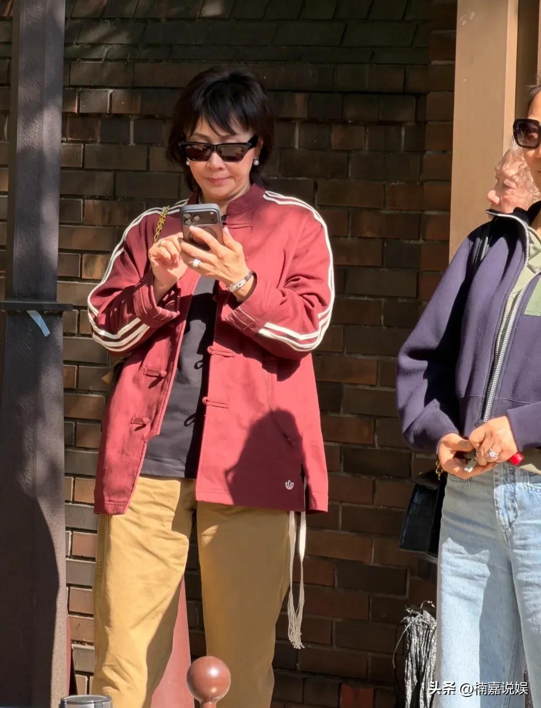 刘嘉玲现身日本东京，换了发型的她，看着顺眼多了。
她穿着一件酒红色中式配黄色休闲