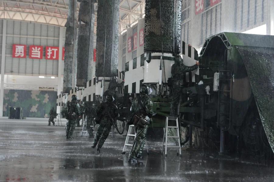 在模拟的大雨环境中进行的训练，解放军士兵在DF-15B短程弹道导弹上安装鳍片上的