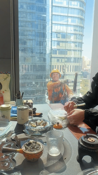 一边是正在吃工作餐的公司白领。
另一边是为了生活努力赚钱的打工人。
这个吊在高空