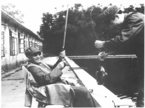 姜太公钓鱼，愿者上钩！照片中，这位戴着帽子和墨镜的老人笑得合不拢嘴，他一定有不错