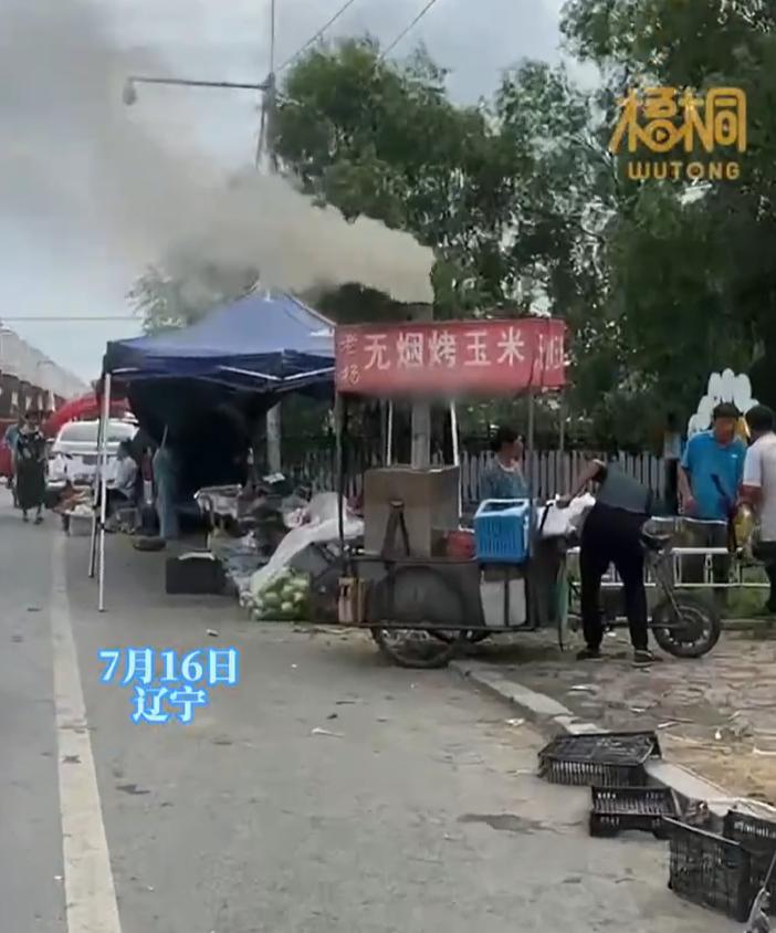 【，网友：没有烟，那是玉米的怨气】7月16日，辽宁。路人见写着无烟烤玉米的小吃摊