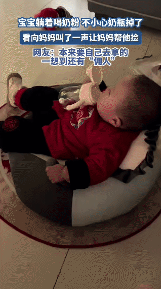 宝宝躺着喝水时，手里的奶瓶不小心掉了，小家伙先是露出小委屈的模样，接着扭头看向妈