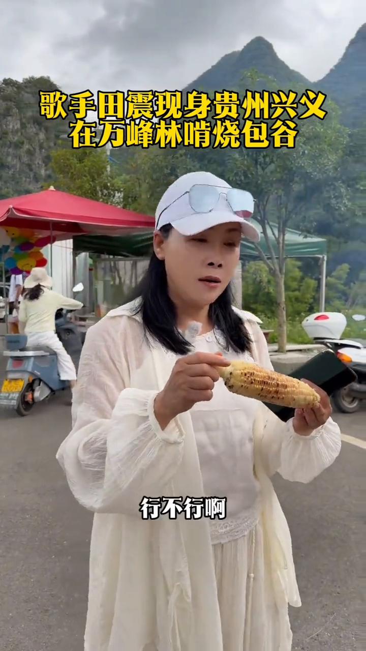 歌手田震现身贵州兴义，在万峰林啃烧包谷。
这玉米5块钱一个，让我看一眼好吗？我来