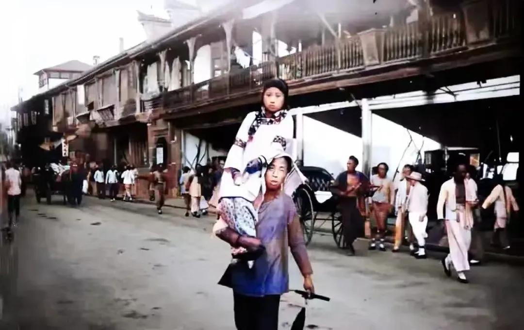 晚清时期，一名“龟奴”肩上扛着女孩，正准备送女孩外出接客，照片中的女孩年龄不大，