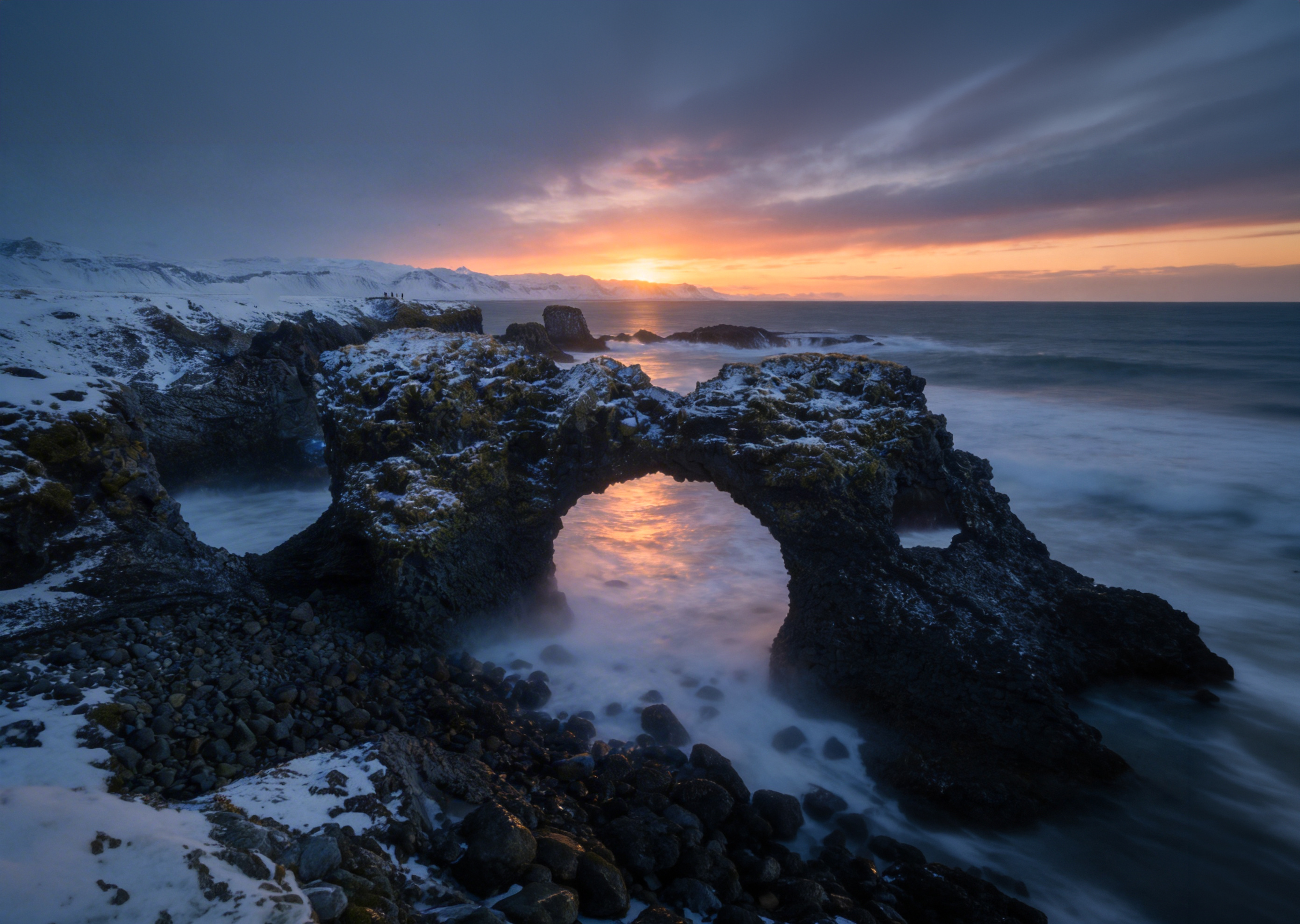 冰岛斯奈山半岛，守候黑夜终结。第一缕晨曦穿透海蚀拱门，整个世界都被温柔地点亮。一