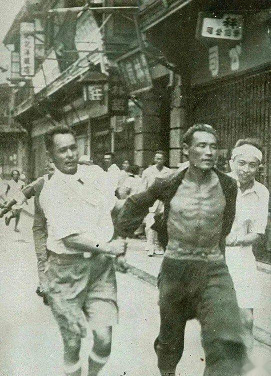 1937年，一名国军的侦察员被抓住的照片，两个日本人将这位先辈双手控制，押送途中