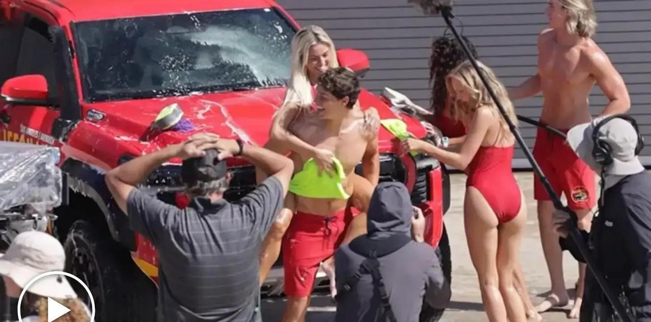 洛杉矶海滩上，奥利维亚·邓恩直接从救生卡车滑下，双手搭在光膀子诺亚·贝克肩头，两