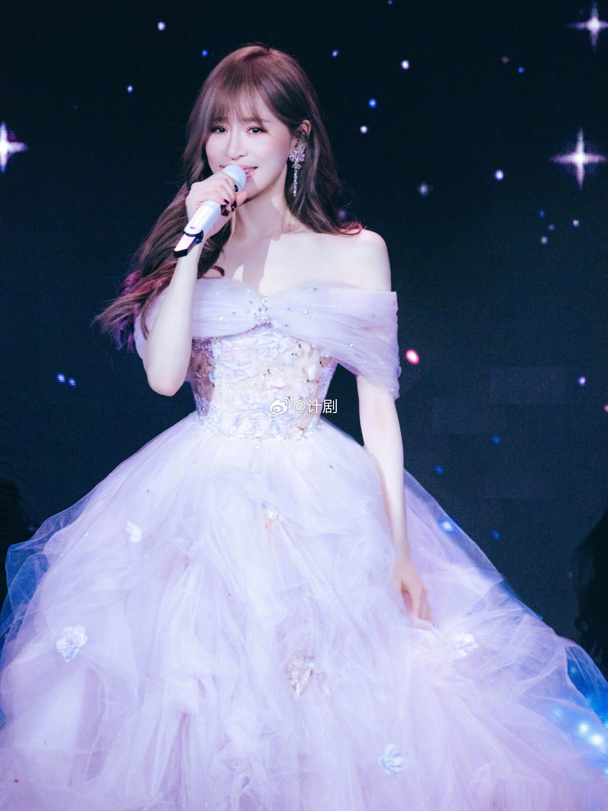 王心凌穿着婚纱唱花的嫁纱微博演出大赏 粉色婚纱自带柔光滤镜，王心凌站在舞台中央，