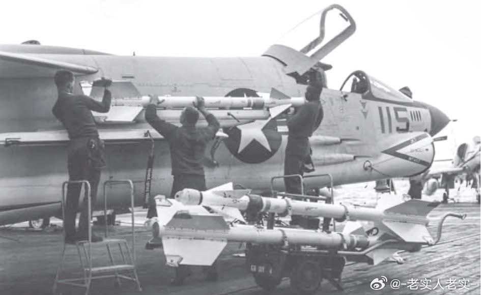提康德罗加号航母的地勤正在为一架F8E战机挂载响尾蛇导弹，摄于1964年2月的北