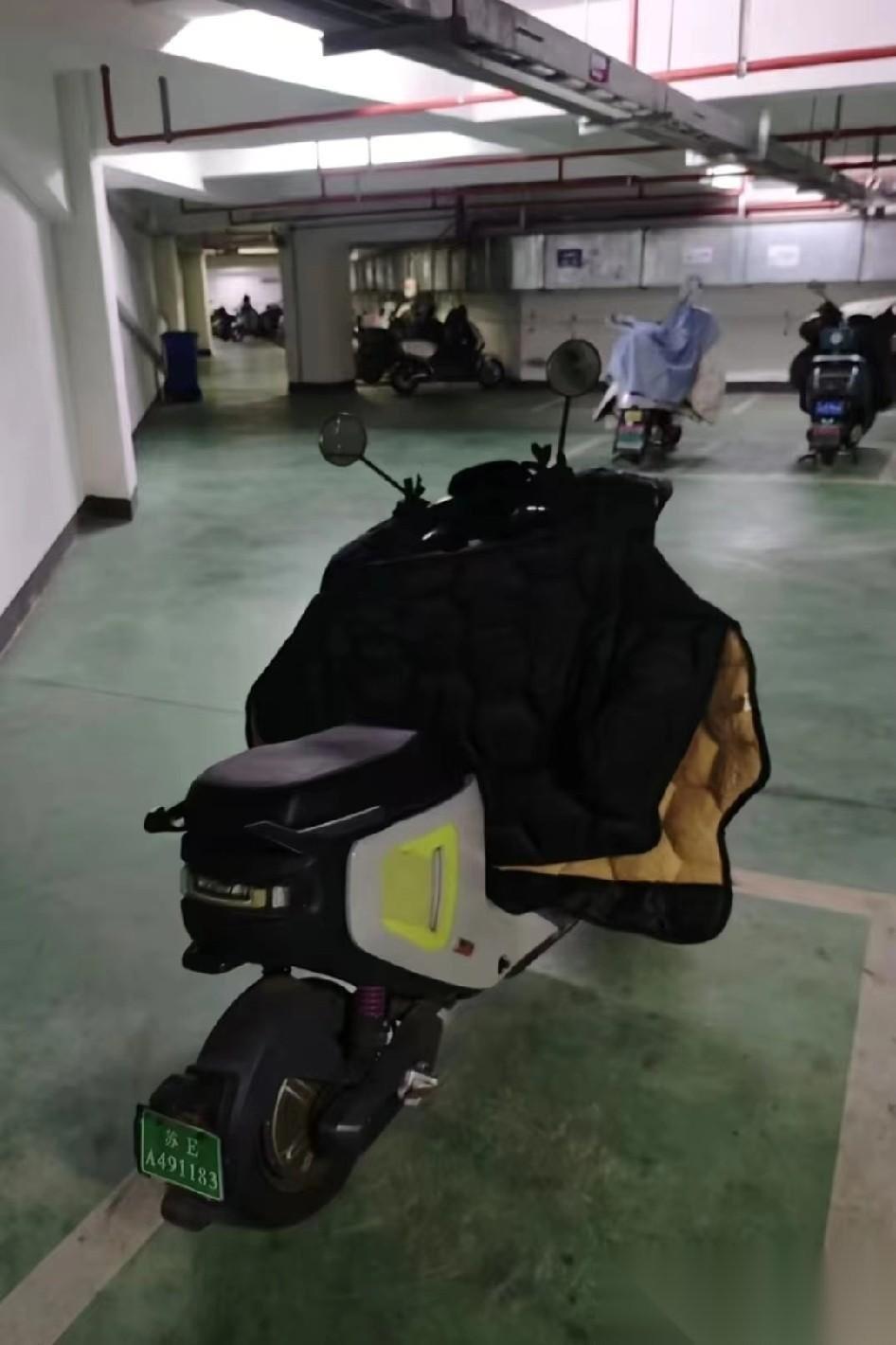 张老师的电动车已经被挪到地下车库，员工给它找了个专属车位。这电动车，是小牛的，价