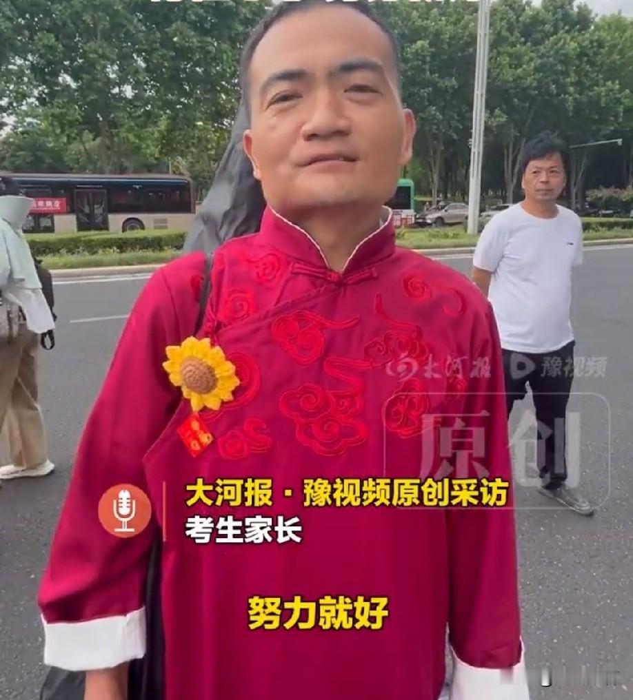 高考奇葩又出现了。
考生的爸爸穿着红色的旗袍，别着向日葵，成为了考场外最大的显眼