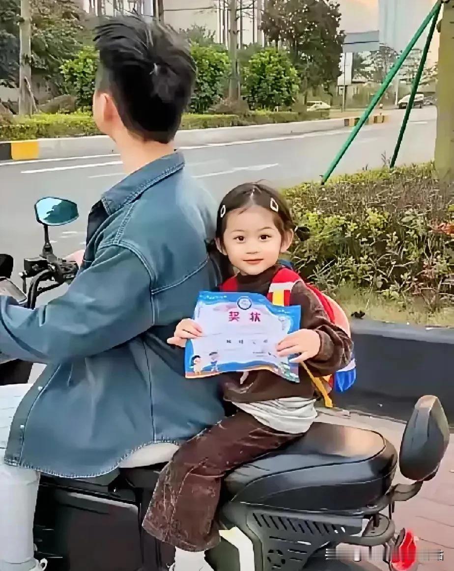 今天放学接孩子时看这一幕，我们同时在等红绿灯。孩子爸爸接女儿放学回家，途中遇红灯