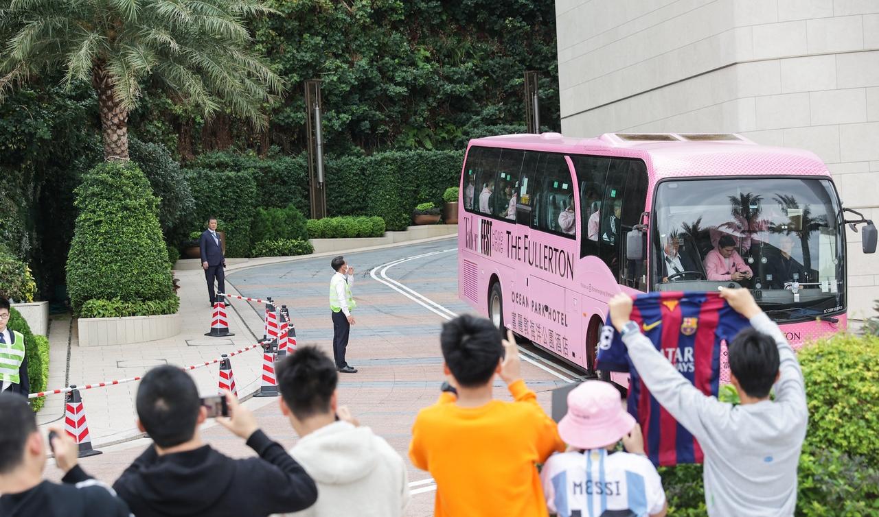 迈阿密国际足球队坐大巴前往机场离开香港，梅西坐在车尾位置面无表情，现场还有球迷来