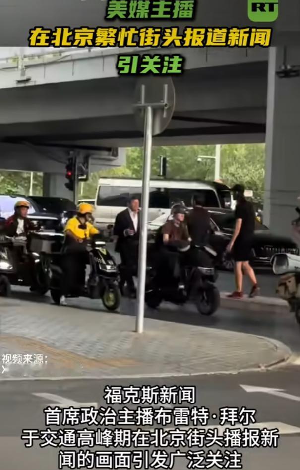 离谱！美媒主播在北京街头播报新闻，高峰时段直冲非机动车道，给人的感觉像是网红拍段