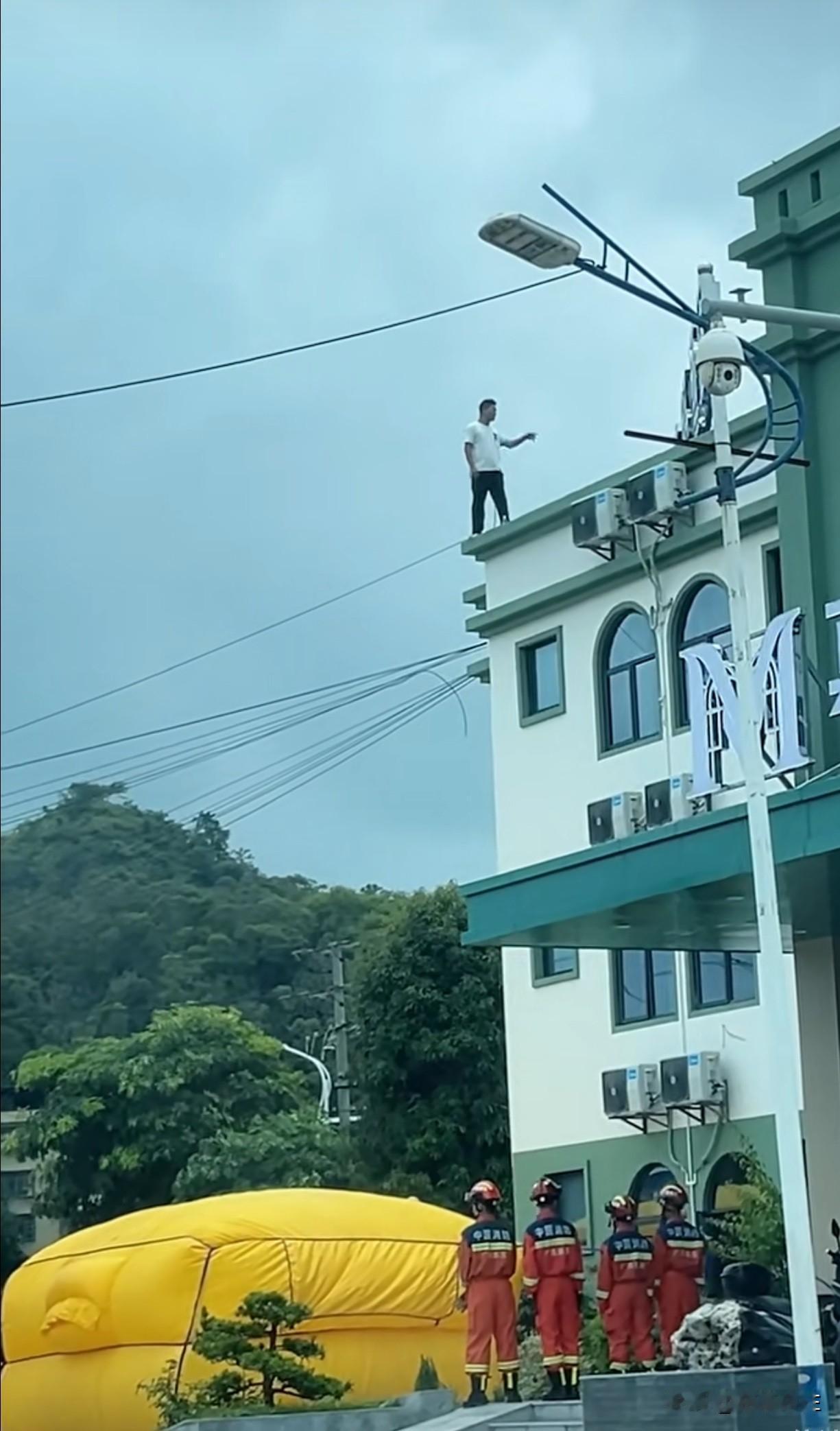 这是近日某地消防部门展开营救行动的现场照片，尽管楼层不高，但营救人员尽显职业操守