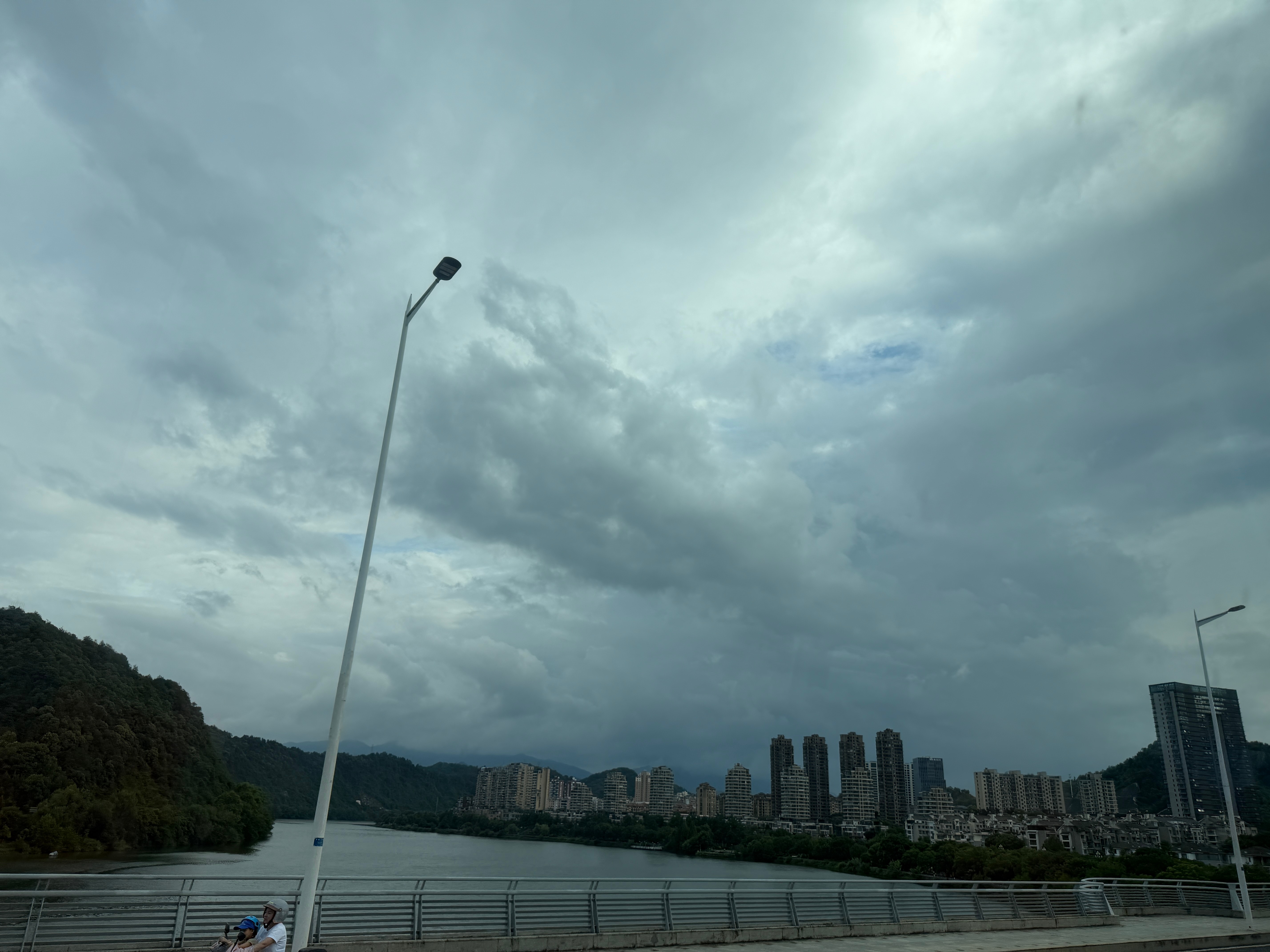 下班了，下班了。天色虽未落雨，但仍悬着几朵乌云，浮在半空，偏巧把西沉的日头给挡的